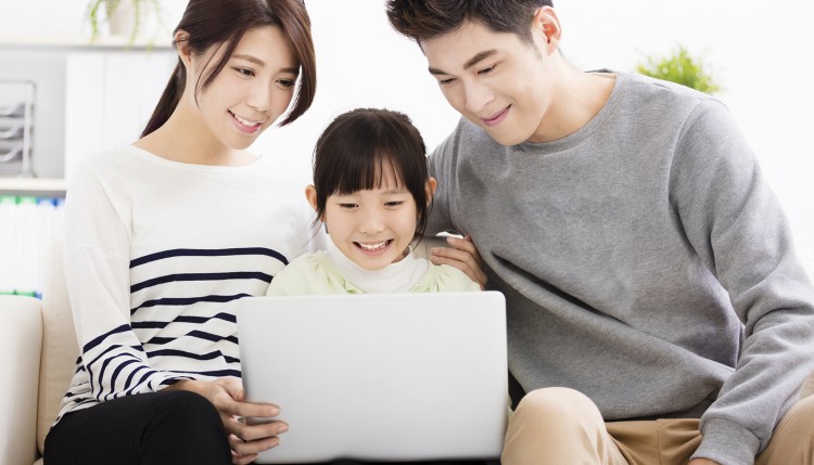 Happy Attractive Young Family watching the laptop